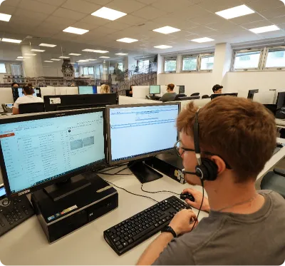 Un team di operatori in open space, ognuno su due monitor, eroga assistenza in telehealth tramite call center